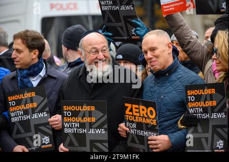 Migliaia di persone marciano contro l'antisemitismo a Londra, con figure di spicco che guidano la marcia, tra cui il rabbino capo e molti attori. Un uomo ha arrestato e messo in furgone della polizia. Foto Stock