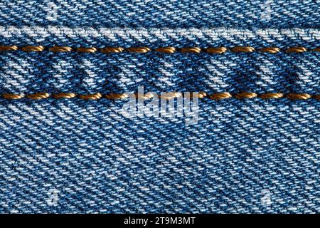 Tessuto denim, struttura di sfondo, cuciture con fili dorati, vista macro ravvicinata Foto Stock