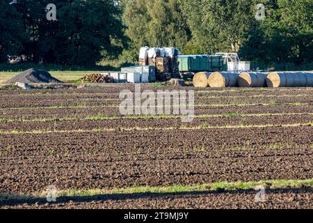 Amburgo, Germania - 09 13 2023: Vista di un campo appena arato con balle di paglia laminate e materiali sullo sfondo. Foto Stock