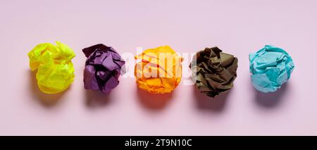 Palle di carta colorata sgualcita su sfondo rosa, idea creativa e concetto di ispirazione Foto Stock