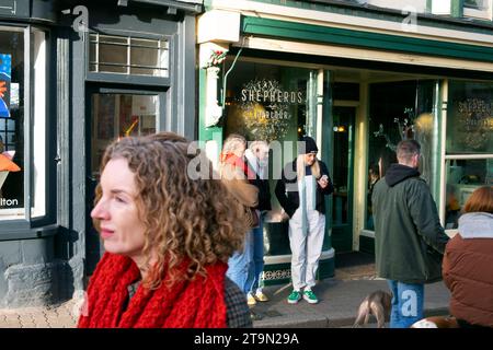 Persone al di fuori di Shepherds Parlour nella città di Hay-on-Wye a Christimas durante i festival del libro Hay Winter Festival in Galles, UK KATHY DEWITT Foto Stock