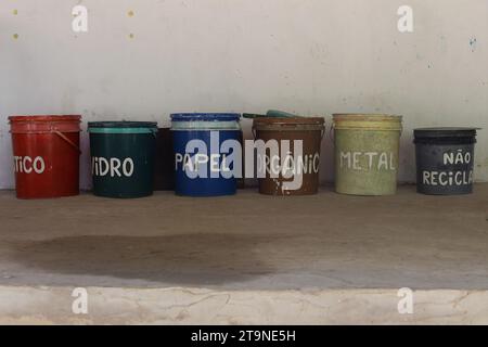 Contenitori di raccolta selettivi semplici, colorati e realizzati a mano per separare i rifiuti riciclabili, realizzati riutilizzando vecchi secchi, in una scuola di Bahia, Brasile. Foto Stock