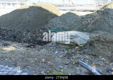 Frantumazione dell'asfalto su strada per raccogliere le acque reflue durante la costruzione di lavori in terra Foto Stock