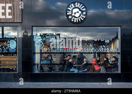 Clienti seduti alla finestra del Black Sheep Coffee in Princes Street, Edimburgo, Scozia, Regno Unito. Foto Stock