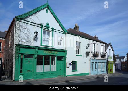 Irlanda, la strada principale di una piccola cittadina con vecchi negozi colorati e ristoranti Foto Stock