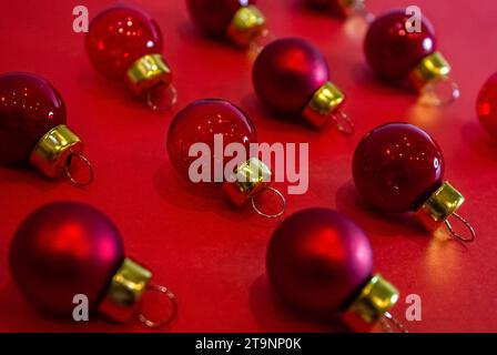 Motivo minimal natalizio - palline rosse di Natale su sfondo rosso. Composizione orizzontale. Base piatta, vista dall'alto. Foto Stock