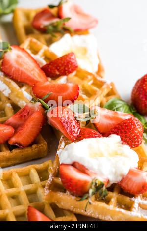 Waffle belgi fatti in casa con fragole e zucchero in polvere. Foto Stock