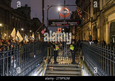 Londra, Regno Unito. 26 novembre 2023. La polizia sigilla l'ingresso della metropolitana alla stazione di Westminster. Decine di migliaia di persone si unirono alla marcia contro l'antisemitismo nel centro di Londra, su una strada dalle Royal Courts of Justice, fino a Parliament Square. Si dice che il raduno sia il più grande del suo genere dalla battaglia di Cable Street nel 1936. Credito: Fotografia dell'undicesima ora/Alamy Live News Foto Stock