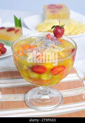 Es Sinom Buah è sciroppo di ghiaccio ottenuto dal succo di giovani foglie di tamarindo con l'aggiunta di frutta come basilico, fragola, papaya e ananas. Foto Stock