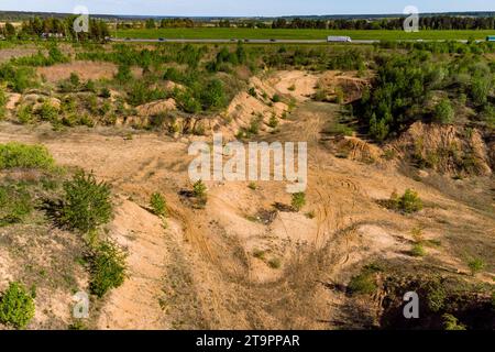 Pozzo esplorativo di sabbia sovradimensionato in un campo, terreno rimosso a strati di sabbia Foto Stock