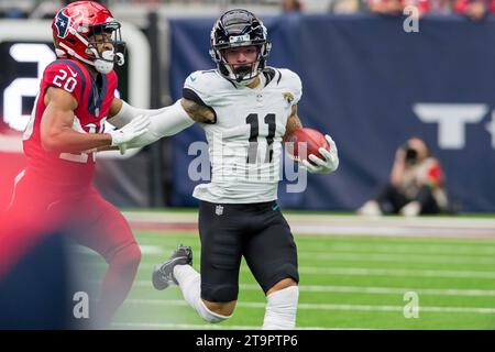 Houston, Texas, Stati Uniti. Houston, Texas, Stati Uniti. 26 novembre 2023. Il wide receiver dei Jacksonville Jaguars Parker Washington (11) ritornò un punt quando il cornerback degli Houston Texans Ka'dar Hollman (20) tentò di fermarsi durante una gara tra i Jacksonville Jaguars e gli Houston Texans a Houston, Texas. Trask Smith/CSM/Alamy Live News Credit: Cal Sport Media/Alamy Live News Foto Stock