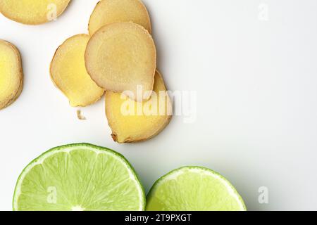 Fette di lime e zenzero su sfondo bianco Foto Stock