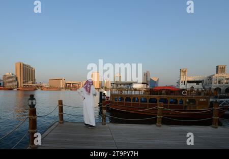 Un uomo saudita che si gode la vista del Dubai Creek e di Deira a Dubai, Emirati Arabi Uniti. Foto Stock