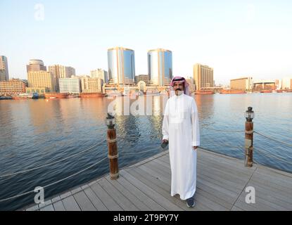 Un uomo saudita che si gode la vista del Dubai Creek e di Deira a Dubai, Emirati Arabi Uniti. Foto Stock