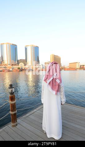 Un uomo saudita che si gode la vista del Dubai Creek e di Deira a Dubai, Emirati Arabi Uniti. Foto Stock