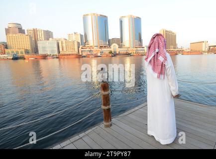 Un uomo saudita che si gode la vista del Dubai Creek e di Deira a Dubai, Emirati Arabi Uniti. Foto Stock