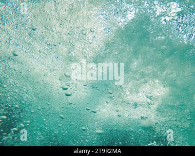 Bolle d'aria subacquea in acqua blu pulita dell'oceano come sfondo naturale, vista dall'angolo basso Foto Stock