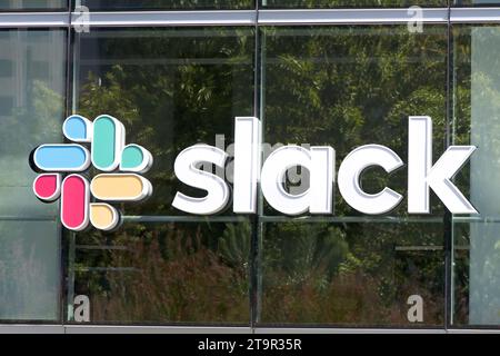 San Francisco, CA - 12 agosto 2023: Cartellone sulla finestra dell'edificio di fronte al parco sul tetto. Slack è un'app di messaggistica per le aziende che connette le persone Foto Stock