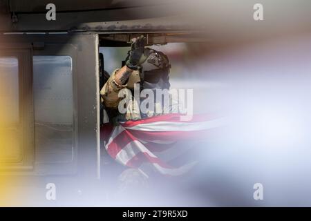 Il membro dell'esercito americano sventolava la bandiera americana da un elicottero al Bucarest International Air Show (BIAS 2023) Foto Stock