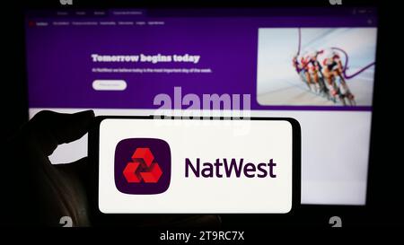 Persona che possiede un telefono cellulare con il logo della società finanziaria National Westminster Bank (NatWest) davanti alla pagina Web. Concentrarsi sul display del telefono. Foto Stock