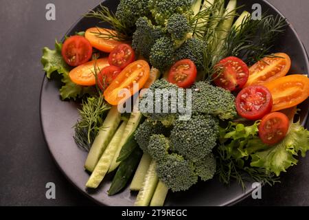 fotografa una deliziosa insalata di verdure la freschezza del cetriolo, dei pomodori ciliegini, dei broccoli e della lattuga croccante. Con un tocco di aneto, è un medl perfetto Foto Stock