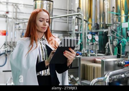 Ritratto di una ingegnere specialista che utilizza tablet computer in fabbrica. Foto Stock
