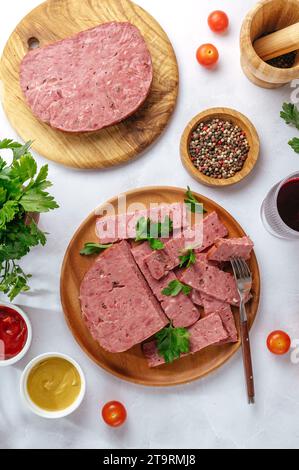 salumi tagliati su un piatto di legno Foto Stock
