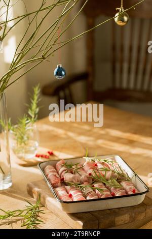 Tradizionale piatto natalizio "maiali in coperta" salsicce avvolte con pancetta Foto Stock