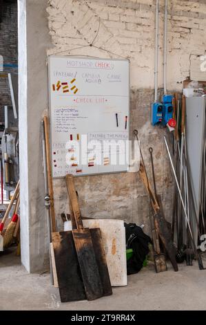 Un elenco di lavoro giornaliero per laboratori - in inglese oltre a una fila di strumenti per la lavorazione del vetro presso la fornace in vetro Wave Murano, sull'isola di Murano, vicino a Venezia, in questo Foto Stock