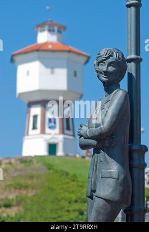 La statua di Lale Andersen (Lili Marleen) con la torre dell'acqua sull'isola del Mare del Nord di Langeoog, Germania Foto Stock