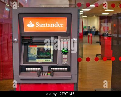 Un bancomat (Automatic Teller Machine) fuori da una filiale di Santander nel Regno Unito. L'interno della banca è visibile sullo sfondo. Foto Stock