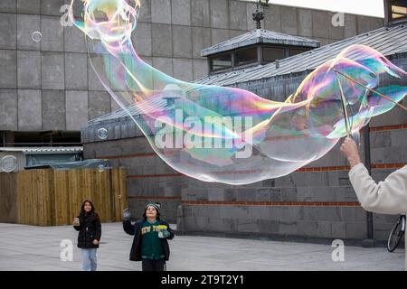 L'uomo fa enormi bolle di sapone vicino alla cattedrale di Colonia, Germania. ###EDITORIALE USE ONLY### Mann macht grosse Seifenblasen nahe Dom, Koeln, Deutsc Foto Stock