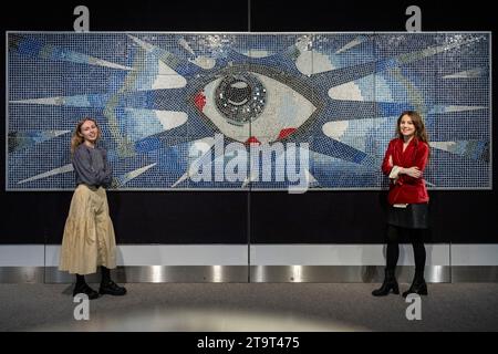 Londra, Regno Unito. 27 novembre 2023. Membri dello staff con "The Psychedelic Eye" Mosaic, circa 1965, creato da Joseph [Joe] ritrovato, un maestro di mattonelle, commissionato da John Lennon per la sua piscina presso la sua casa di Kenwood comprendente circa 17.000 piastrelle policrome e l'Iris formato da piastrelle in vetro specchio (prezzo stimato su richiesta) in anteprima della vendita di Bonhams’ Rock, Pop & Film. La vendita ha luogo nelle gallerie Bonhams Knightsbridge il 29 novembre. Crediti: Stephen Chung / Alamy Live News Foto Stock