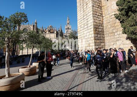 Turisti in coda fuori dal Real Alcazar, Cattedrale sullo sfondo, Siviglia, Andalusia, Spagna, Europa. Foto Stock