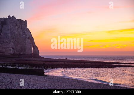 Spettacolare vista del tramonto sulla spiaggia e sulla scogliera sul mare sullo sfondo a Étretat, Francia Foto Stock