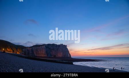 Vista panoramica del tramonto sulla spiaggia e sulla scogliera sul mare sullo sfondo a Étretat, Francia Foto Stock