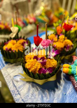 Bangkok, Thailandia. 27 novembre 2023. I Krathongs giacciono su una stalla. Le piccole zattere sono fatte di alberi di banana o polistirene espanso e sono decorate con fiori, bastoncini di incenso e candele. La Thailandia celebra sempre il Loi Krathong festival delle luci nel giorno della luna piena nel dodicesimo mese del calendario tradizionale. I piccoli zattere sono abbassati in acqua nei fiumi o nei laghi per rendere omaggio alla dea indù dell'acqua Mae Phra Khongkha. Crediti: Carola Frentzen/dpa/Alamy Live News Foto Stock