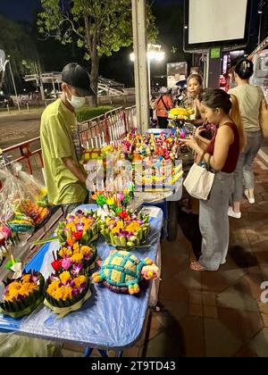 Bangkok, Thailandia. 27 novembre 2023. I thailandesi acquistano il cosiddetto Krathong, piccoli zattere di banane o polistirene espanso con fiori, bastoncini di incenso e candele, presso le bancarelle. La Thailandia celebra sempre il Loi Krathong festival delle luci nel giorno della luna piena nel dodicesimo mese del calendario tradizionale. I piccoli zattere sono abbassati in acqua nei fiumi o nei laghi per rendere omaggio alla dea indù dell'acqua Mae Phra Khongkha. Crediti: Carola Frentzen/dpa/Alamy Live News Foto Stock