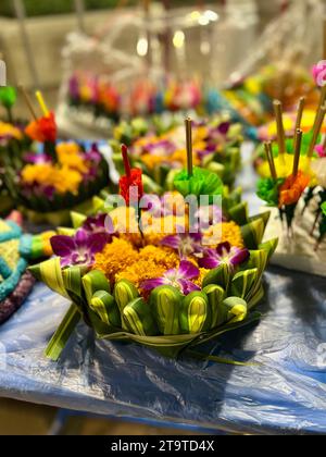 Bangkok, Thailandia. 27 novembre 2023. I Krathongs giacciono su una stalla. Le piccole zattere sono fatte di alberi di banana o polistirene espanso e sono decorate con fiori, bastoncini di incenso e candele. La Thailandia celebra sempre il Loi Krathong festival delle luci nel giorno della luna piena nel dodicesimo mese del calendario tradizionale. I piccoli zattere sono abbassati in acqua nei fiumi o nei laghi per rendere omaggio alla dea indù dell'acqua Mae Phra Khongkha. Crediti: Carola Frentzen/dpa/Alamy Live News Foto Stock