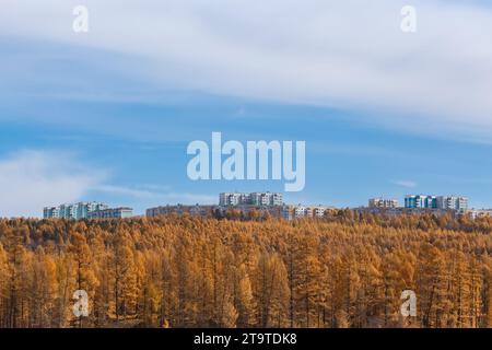 Vista di parte della città di Neryungri nel sud di Yakutia, Russia. Paesaggio autunnale con vista sugli edifici cittadini su una collina. Foto Stock