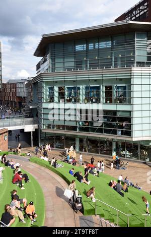 Gli acquirenti si fermano sulle terrazze artificiali in erba presso il centro commerciale Liverpool One City Centre e il moderno John Lewis Building Liverpool Inghilterra Regno Unito Foto Stock