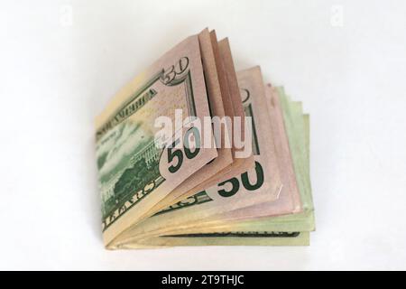 Un mucchio di banconote da dollaro su sfondo bianco Foto Stock