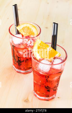 in cima alla vista di due bicchieri di aperitivo di spritz cocktail di aperol con fette d'arancia e cubetti di ghiaccio su tavolo di legno Foto Stock