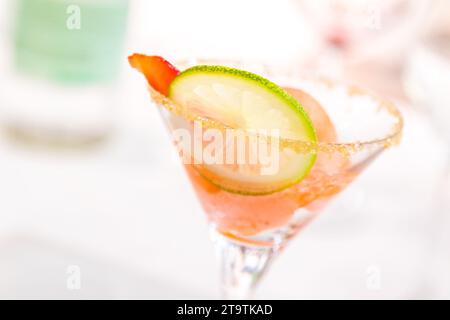 bicchiere di caipiroska con gelato, fetta di fragola e lime sul tavolo da sposa; bicchiere di caipiroska con gelato, fragola e fetta di lime sul tavolo da sposa Foto Stock