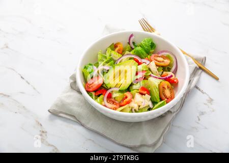 Insalata verde sana con avocado, pomodori, mozzarella e cipolle rosse Foto Stock