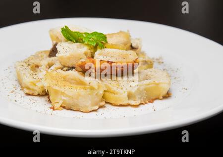 piatto di pasta italiana con funghi porcini e salsa besciamella con pepe su tavola nera Foto Stock