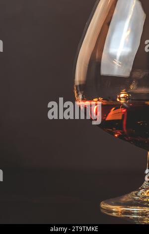 snifter di brandy in elegante tipico vetro cognac su sfondo scuro con spazio per il testo Foto Stock