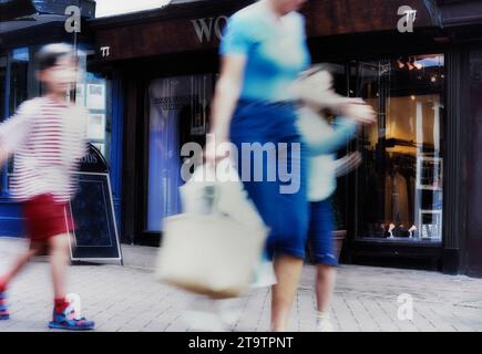Una madre che fa shopping con due bambini. Inghilterra, Regno Unito Foto Stock