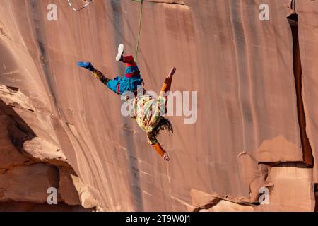 Un Highliner maschile perde l'equilibrio e frusta, o cade fuori dall'Highline, in un festival Highline nello Utah. La sua imbracatura protettiva e il guinzaglio lo tengono lontano Foto Stock