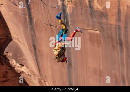 Un Highliner maschile perde l'equilibrio e frulla, o cade fuori dall'Highline in un festival Highline nello Utah. La sua imbracatura protettiva e il guinzaglio lo impediscono Foto Stock